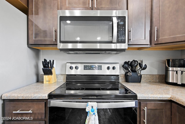 kitchen featuring appliances with stainless steel finishes, light countertops, and dark brown cabinets