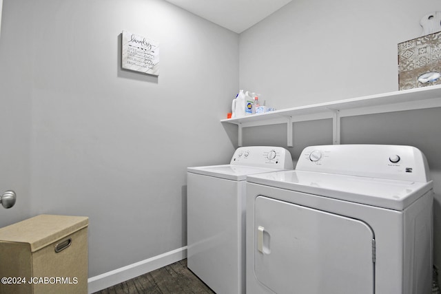 clothes washing area with dark wood-type flooring, washing machine and dryer, laundry area, and baseboards