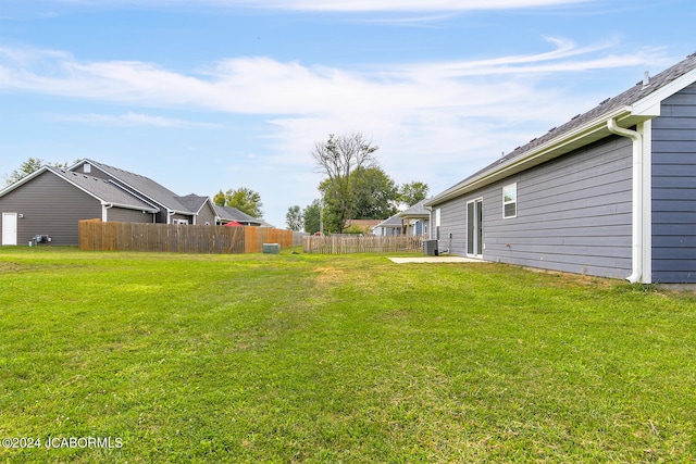 view of yard featuring fence and central air condition unit