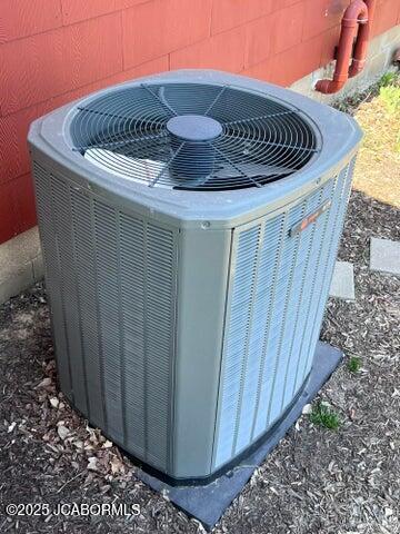 exterior view of central AC unit and concrete block siding