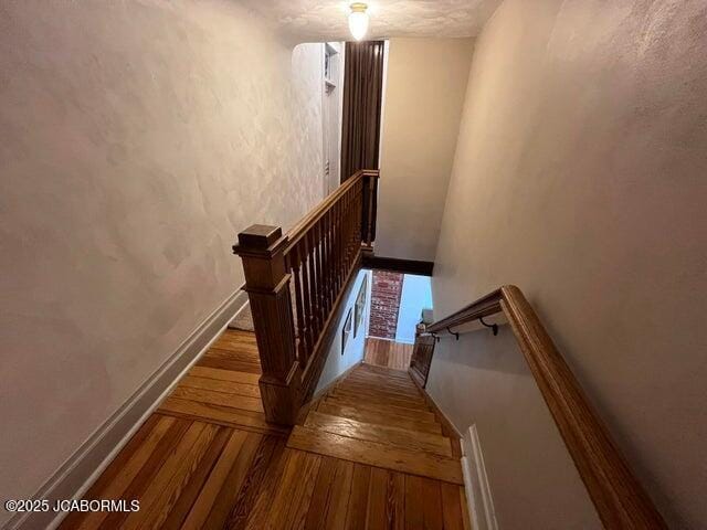 stairway with hardwood / wood-style floors and baseboards