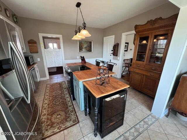kitchen featuring stainless steel appliances, light tile patterned floors, and pendant lighting