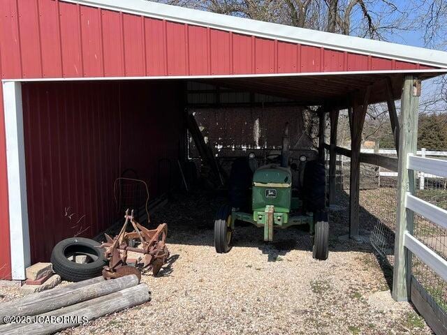 view of parking with an outbuilding and fence