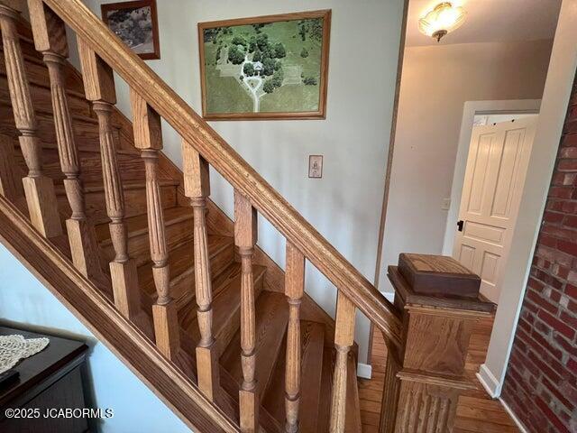 stairs with wood finished floors and baseboards