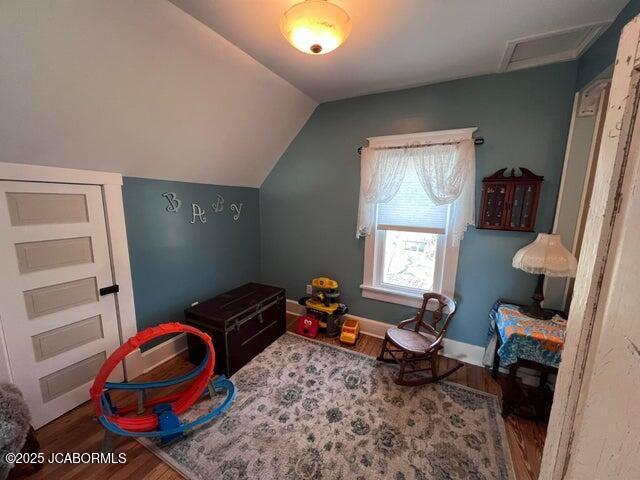 playroom featuring wood finished floors, vaulted ceiling, attic access, and baseboards