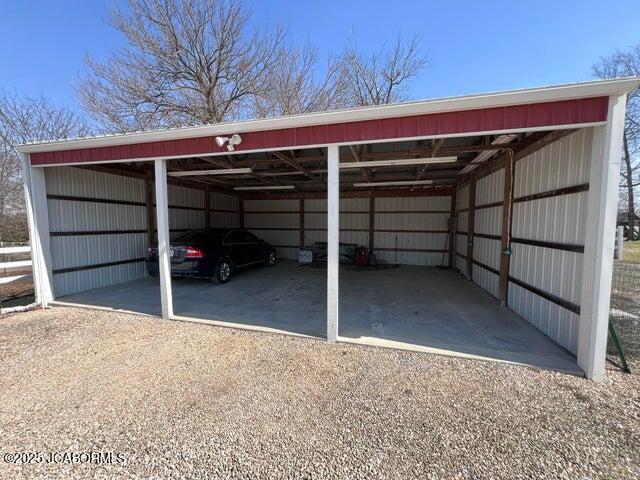 view of parking / parking lot with a detached carport and driveway