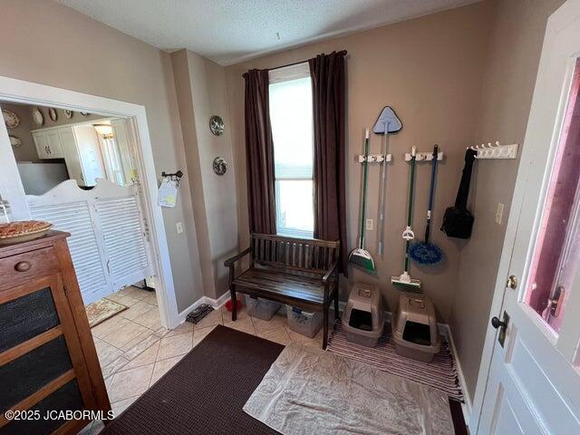 interior space with light tile patterned floors and baseboards