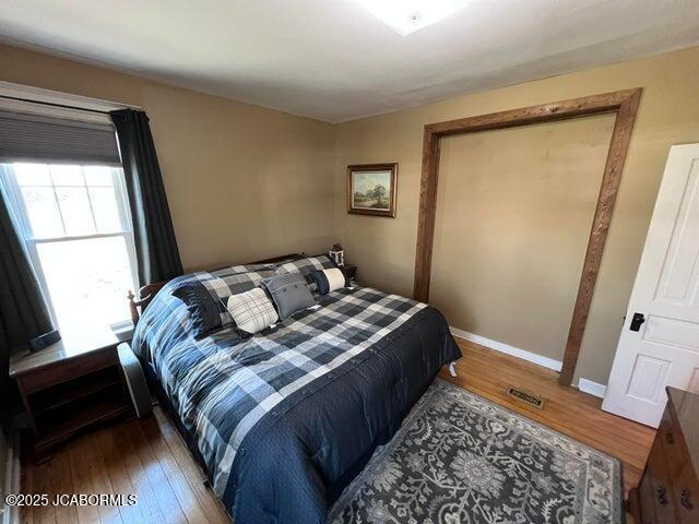 bedroom featuring wood finished floors and baseboards
