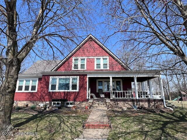 view of front of house featuring covered porch and a front yard