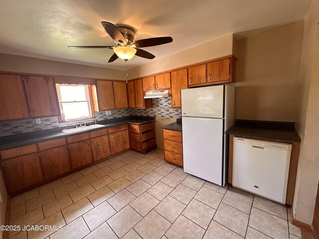 713 Lincoln St, Linn, MO 65051 - kitchen featuring white appliances, a sink, brown cabinetry, under cabinet range hood, and dark countertops
