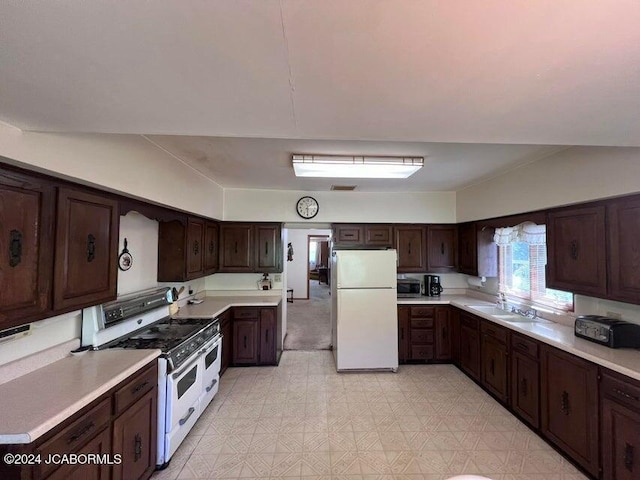 kitchen with dark brown cabinetry, sink, and white appliances