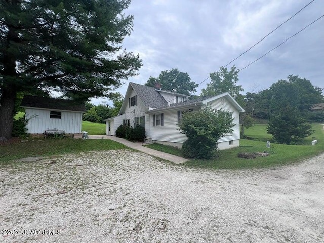 view of side of property featuring a yard and an outbuilding