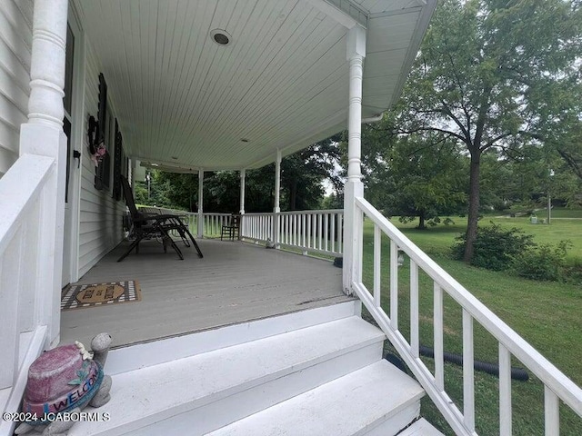 wooden deck featuring a yard and covered porch