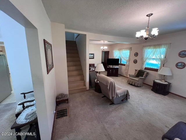 carpeted living room with a notable chandelier and a textured ceiling