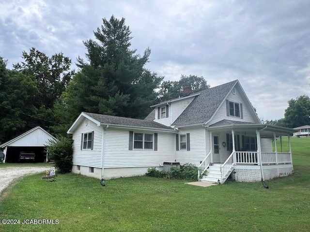 view of front of property featuring an outbuilding, a front lawn, covered porch, and a garage