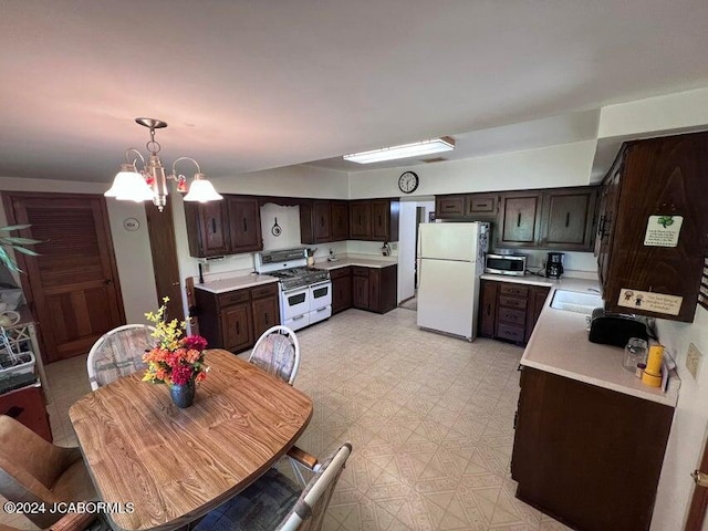 kitchen featuring white appliances, an inviting chandelier, sink, hanging light fixtures, and dark brown cabinetry