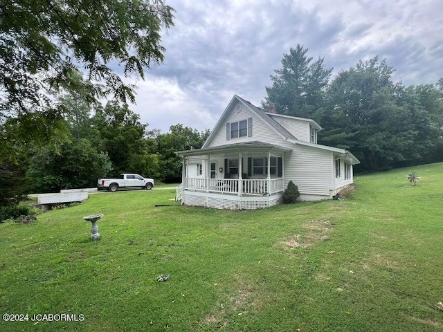 rear view of property with a lawn and covered porch