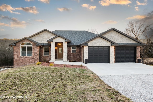 view of front of home featuring a garage, brick siding, driveway, roof with shingles, and a front yard