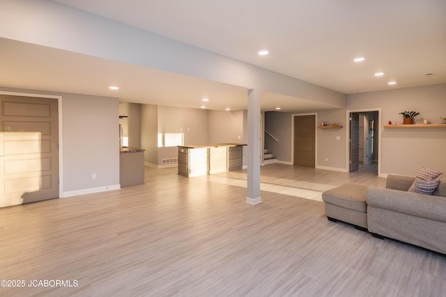 living room featuring light wood-style floors, recessed lighting, baseboards, and stairs