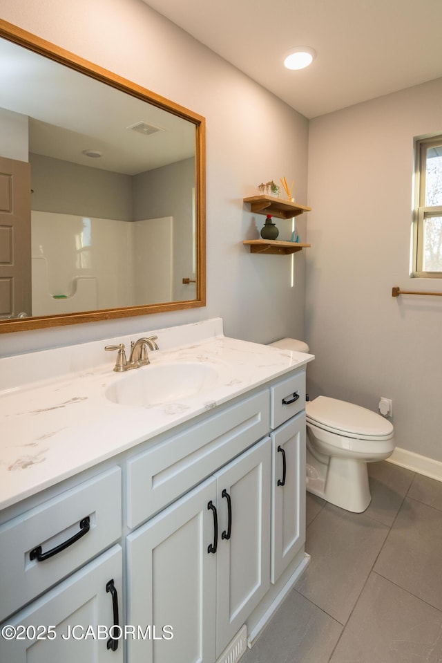 bathroom featuring tile patterned flooring, toilet, vanity, visible vents, and baseboards