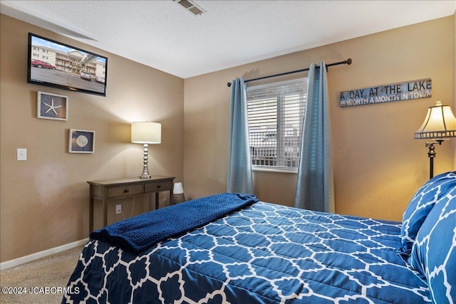 carpeted bedroom featuring a textured ceiling