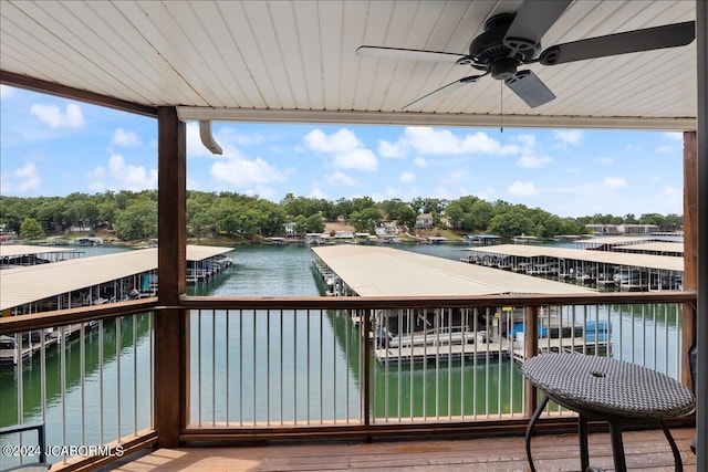 wooden deck with ceiling fan and a water view