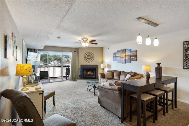 living room with carpet flooring, a textured ceiling, and ceiling fan