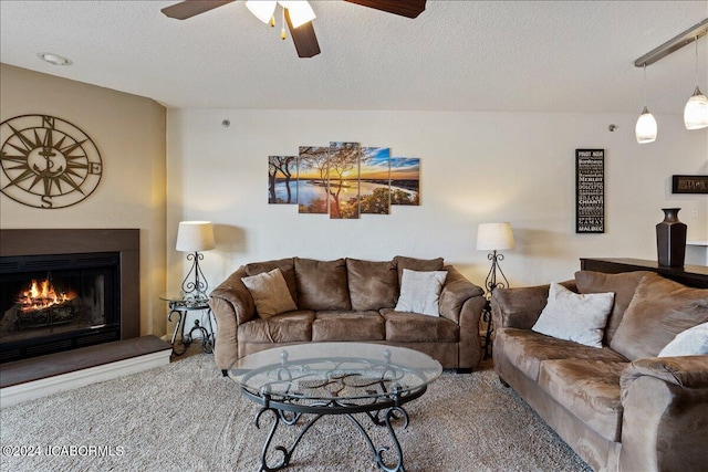 carpeted living room featuring ceiling fan and a textured ceiling