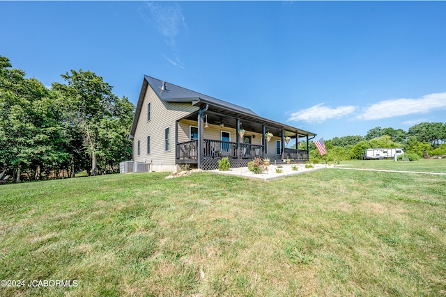 rear view of property with ceiling fan, a porch, a yard, and central AC