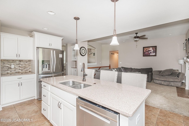 kitchen with appliances with stainless steel finishes, a sink, open floor plan, a center island with sink, and recessed lighting