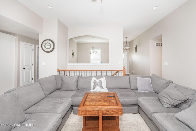 living room with a chandelier, recessed lighting, and arched walkways