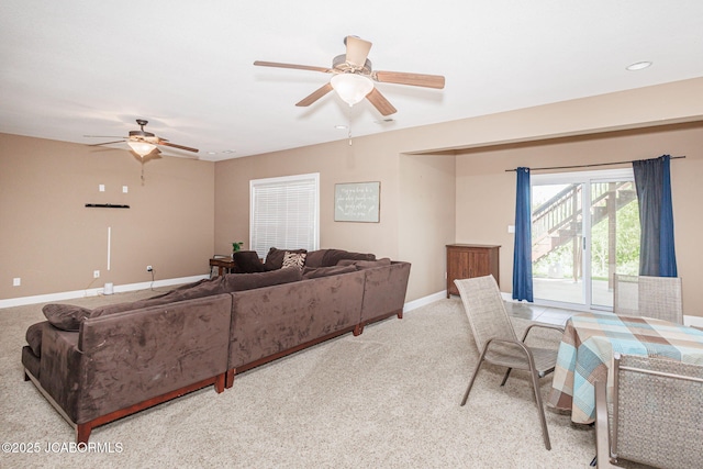 living room featuring ceiling fan, light colored carpet, and baseboards