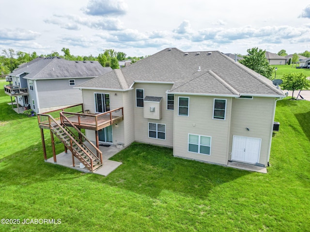 back of house with a patio area, a wooden deck, roof with shingles, a lawn, and stairs