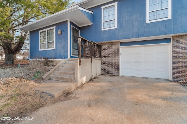 split level home with brick siding, an attached garage, and driveway