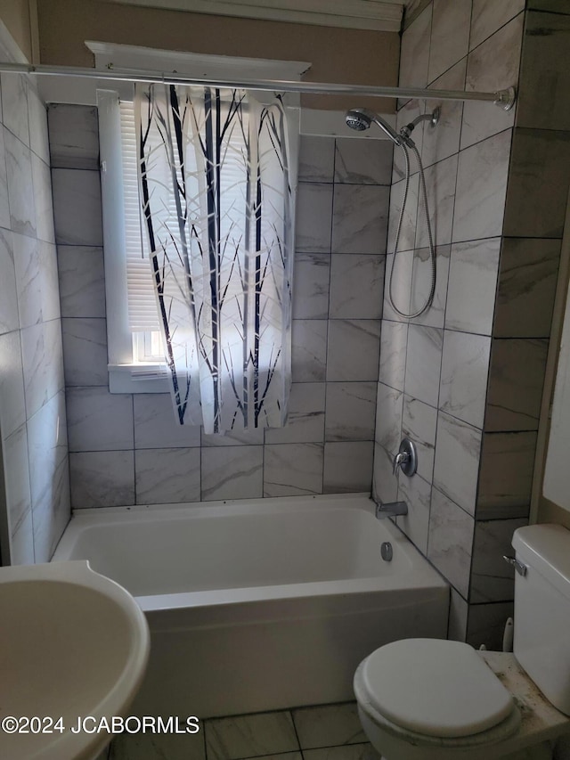 bathroom with tile patterned floors, toilet, and tiled shower / bath