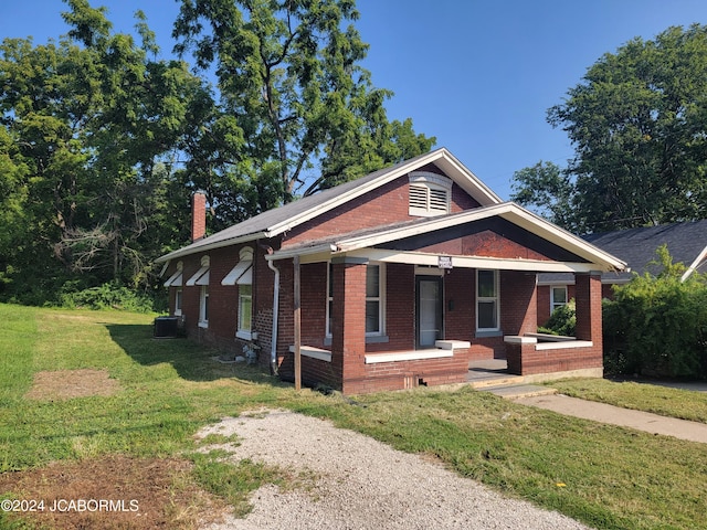 view of front of property featuring covered porch, a front lawn, and cooling unit