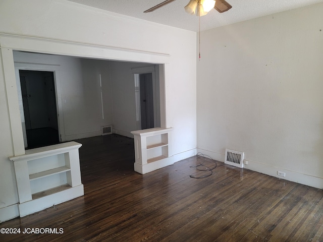 spare room featuring ceiling fan, dark wood-type flooring, and a textured ceiling