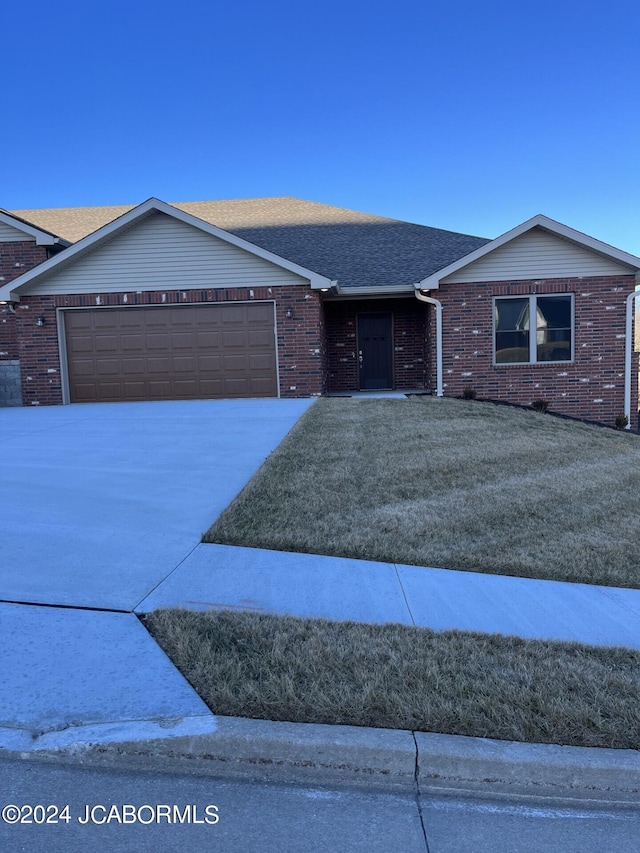 ranch-style home with a front yard and a garage