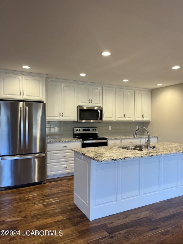 kitchen with light stone countertops, stainless steel appliances, sink, dark hardwood / wood-style floors, and white cabinetry