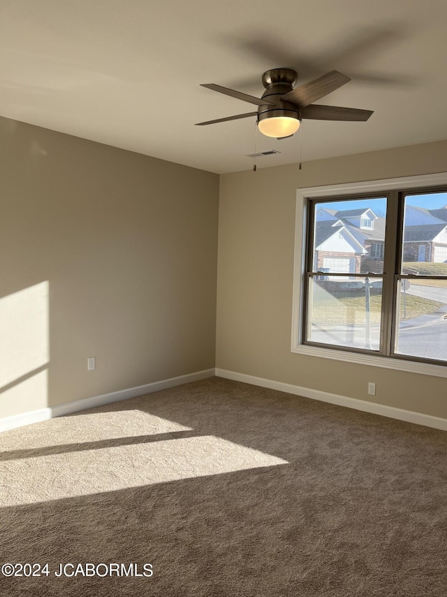 empty room with ceiling fan and carpet