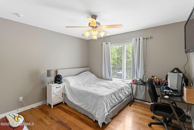 bedroom with light wood-type flooring, baseboards, and ceiling fan