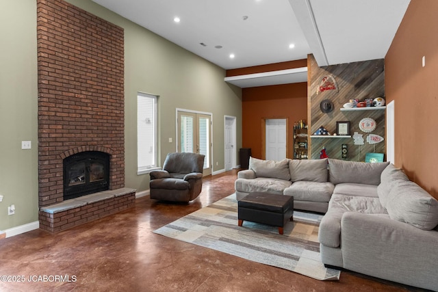 living room featuring a brick fireplace, concrete flooring, baseboards, and recessed lighting