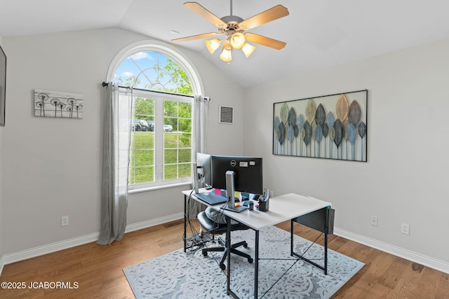 office featuring visible vents, wood finished floors, baseboards, ceiling fan, and vaulted ceiling