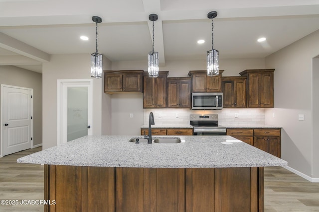1502 Summerfield Dr, Jefferson City, MO 65109 - kitchen with appliances with stainless steel finishes, a sink, light wood finished floors, backsplash, and baseboards