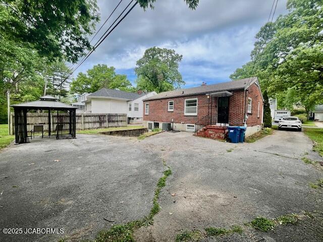 711 Cardinal St, Jefferson City, MO 65101 - back of property featuring a gazebo, brick siding, and fence