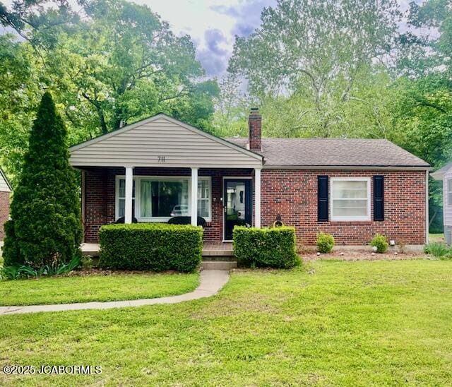 711 Cardinal St, Jefferson City, MO 65101 - view of front of house with brick siding, covered porch, and a chimney