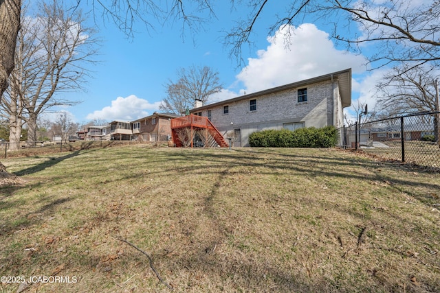 back of property with stairs, a yard, and fence