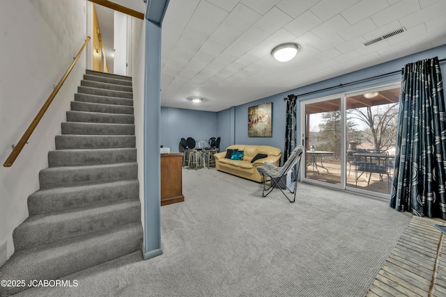 living room featuring visible vents, stairs, and carpet