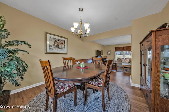 dining room featuring baseboards, wood finished floors, and a chandelier