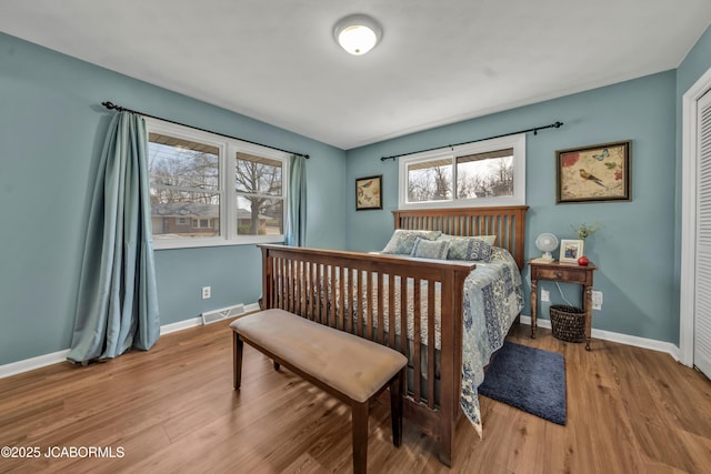 bedroom featuring visible vents, baseboards, and wood finished floors